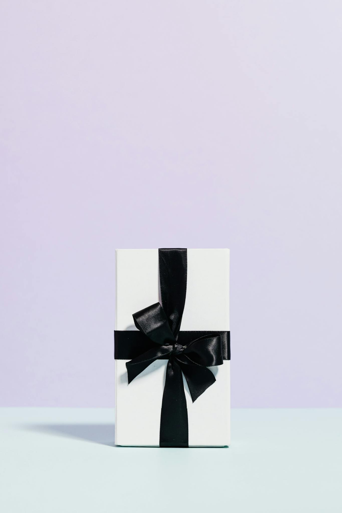 A minimalist white gift box with a black ribbon, perfect for celebrations and special occasions.